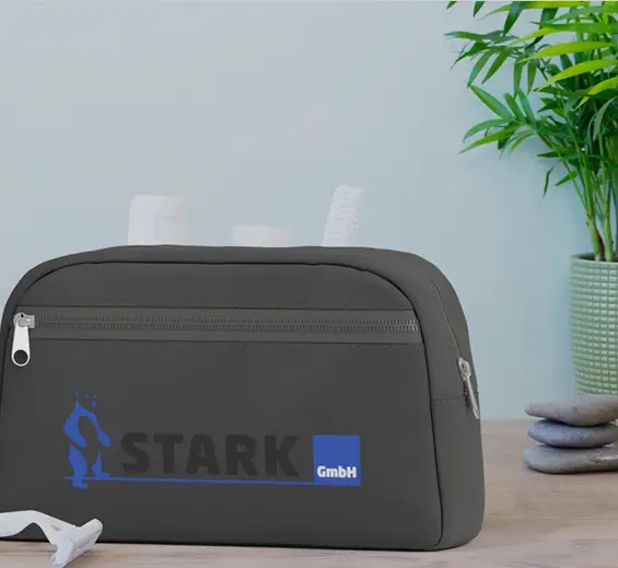 Kosmetiktasche mit Starklogo vor Grünpflanze und gestapelten Steinen